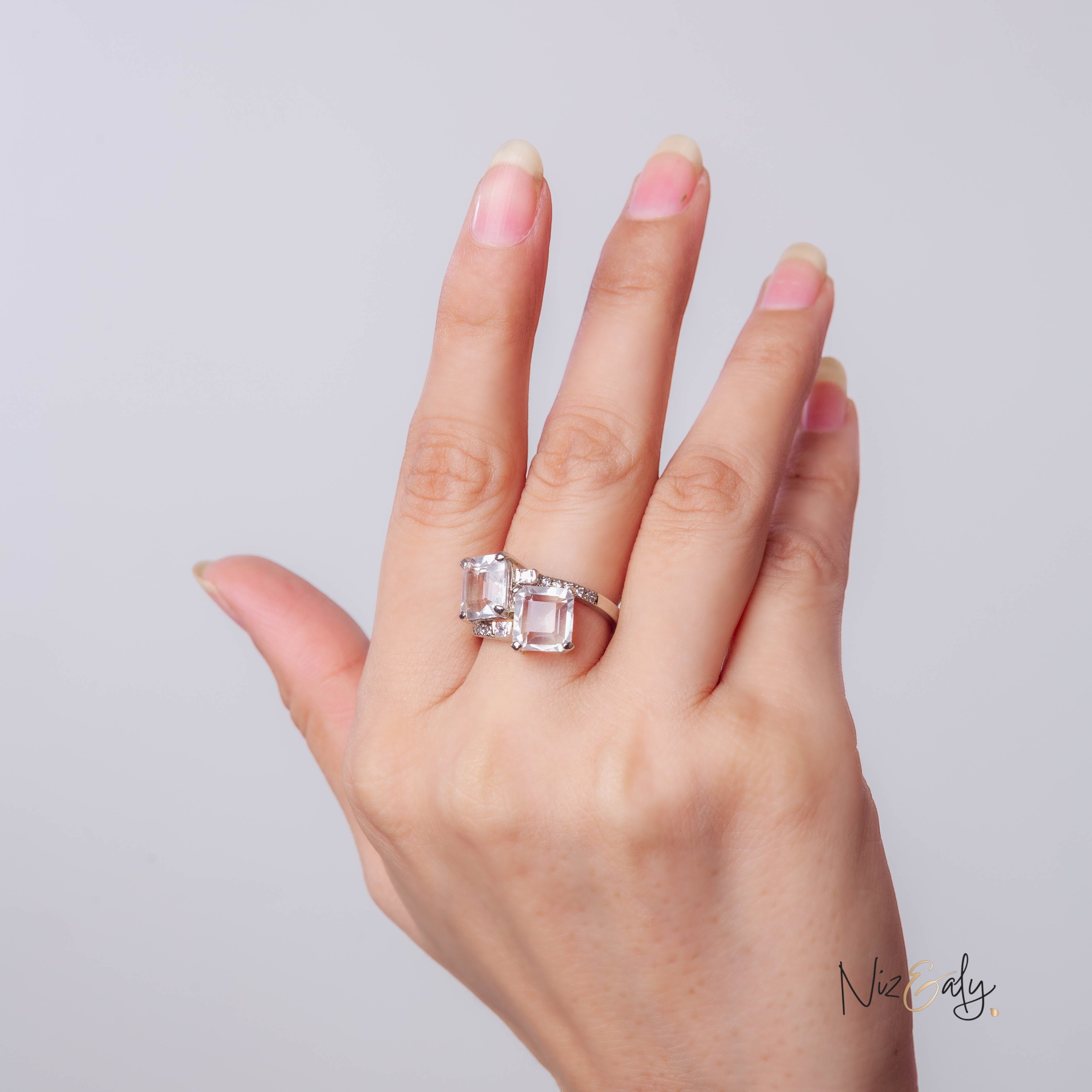 Niz & Aly twin clear quartz ring featuring two radiant stones set in a polished silver band on a hand