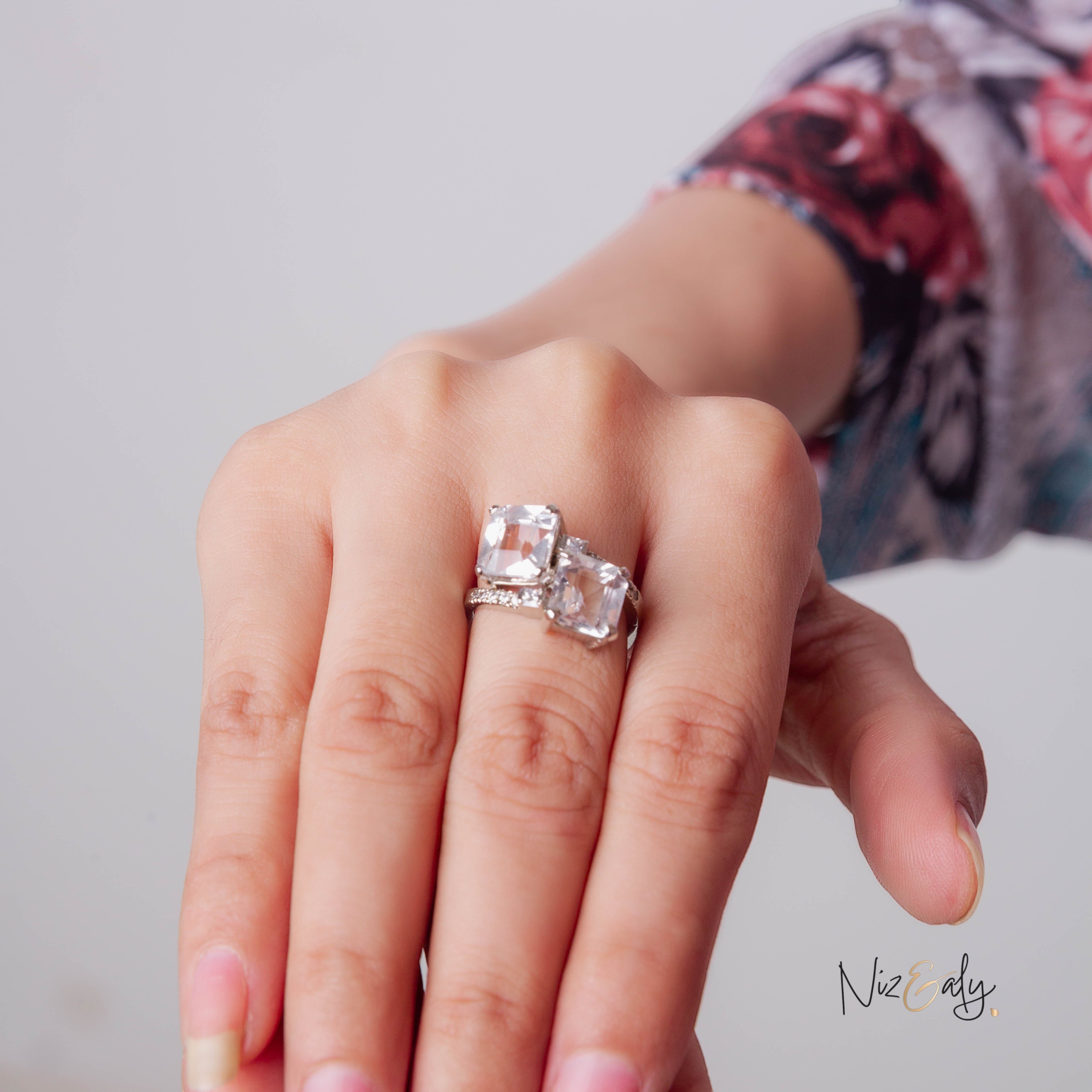 Niz & Aly twin clear quartz ring featuring two radiant stones set in a polished silver band on a woman's finger