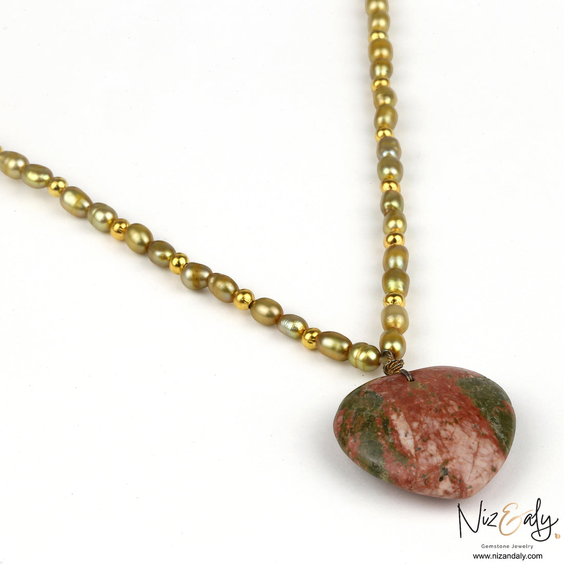 Niz & Aly unakite heart pendant on a strand of golden rice pearls with metallic accents.