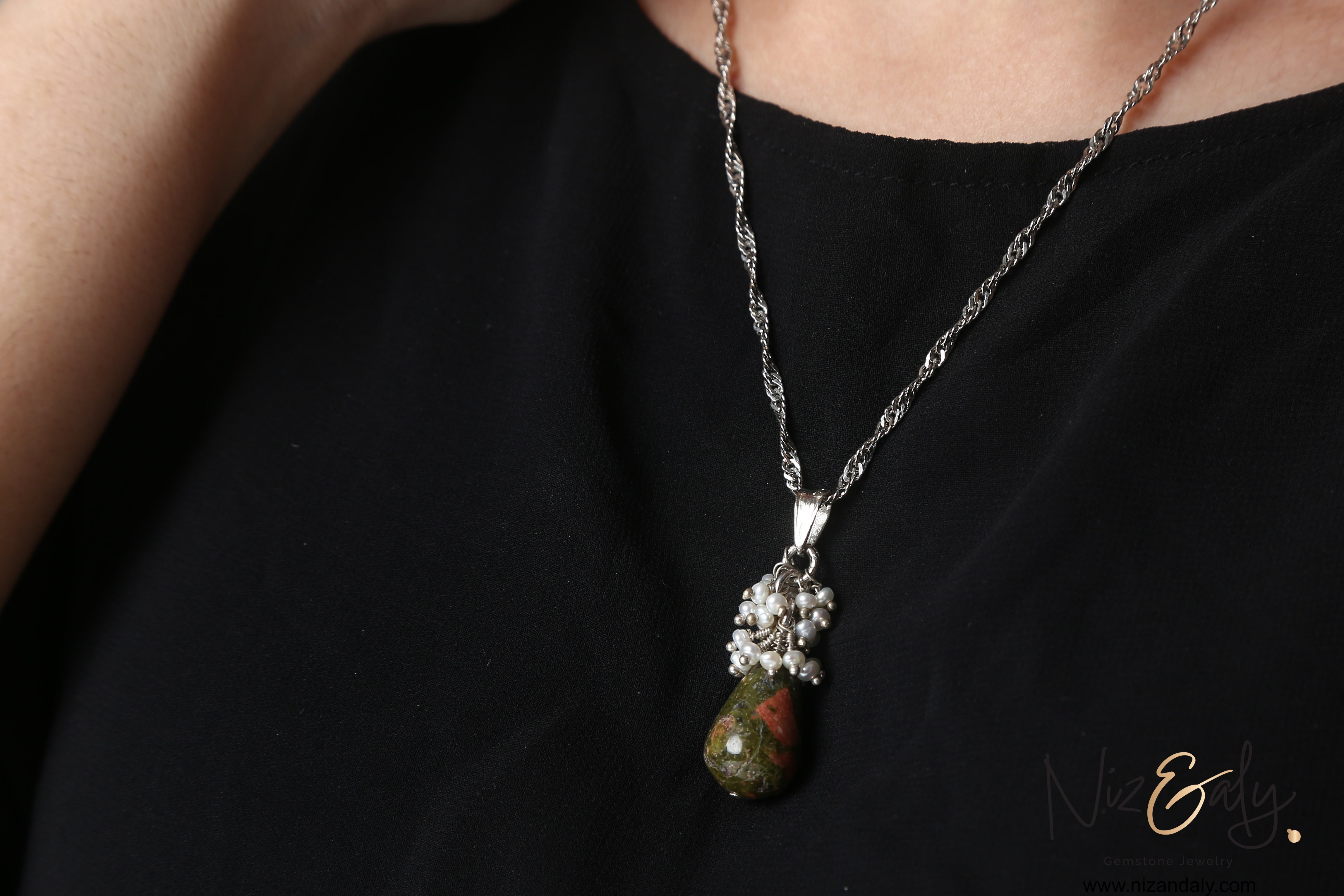 Niz & Aly unakite jasper and freshwater pearl drop pendant necklace worn on a silver chain against a black top