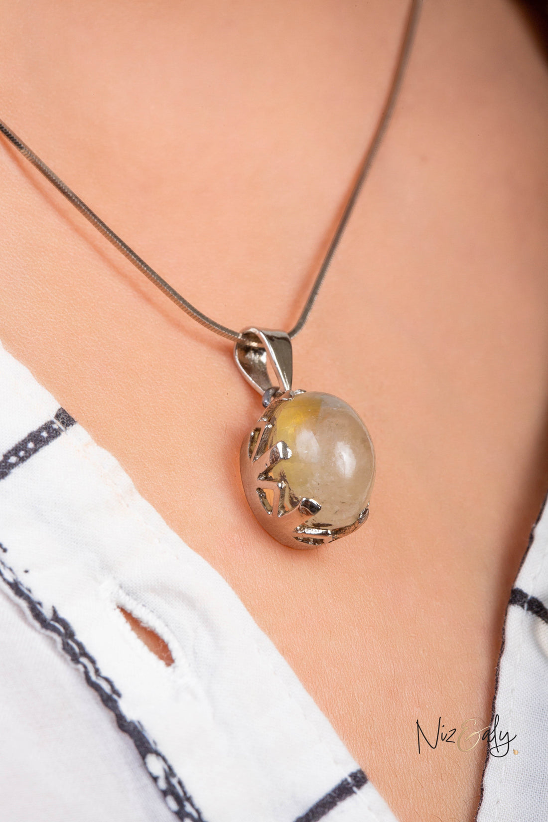 Niz & Aly natural untreated citrine locket pendant with a golden stone in a silver setting worn on a chain