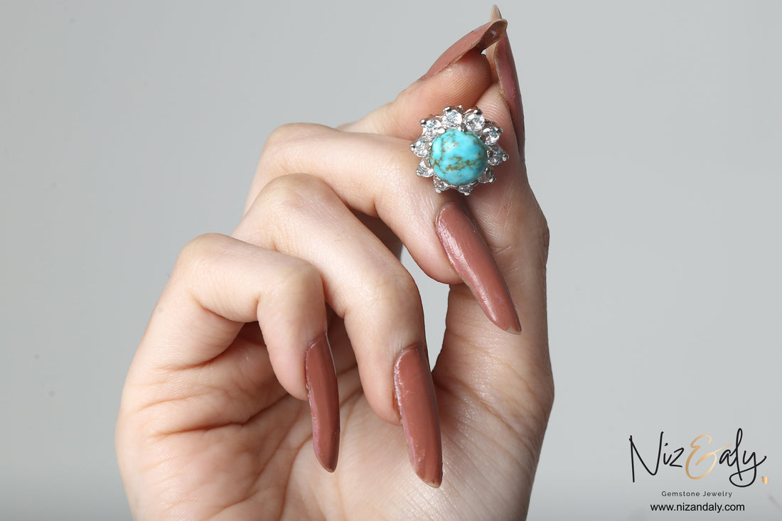 Niz & Aly round vintage blue Kingman turquoise ear stud with a halo of sparkling stones held in a hand