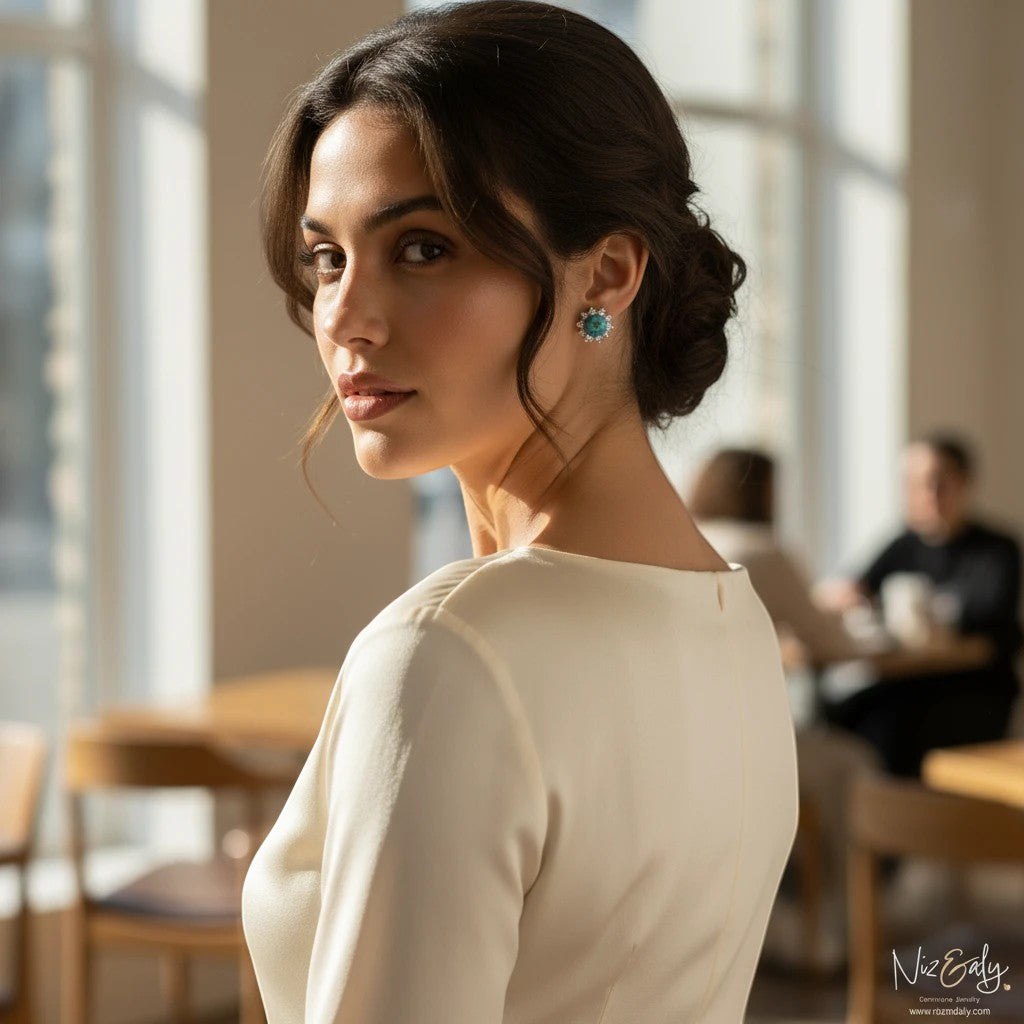 Niz & Aly round vintage Kingman turquoise ear studs worn by a woman in a cream dress in a bright indoor setting.