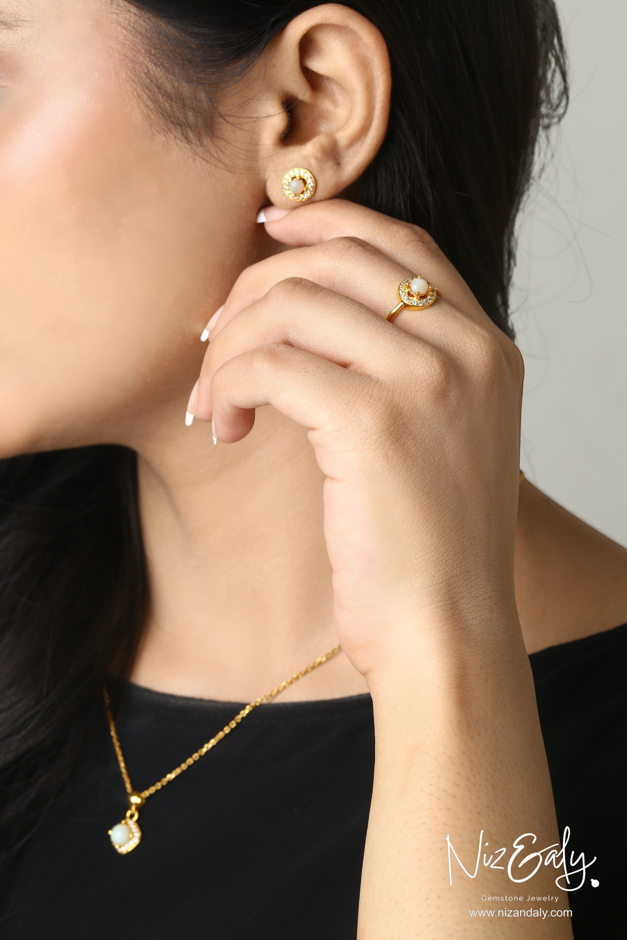 Niz & Aly dainty round white Australian opal necklace, stud earrings, and ring set with halo on a woman