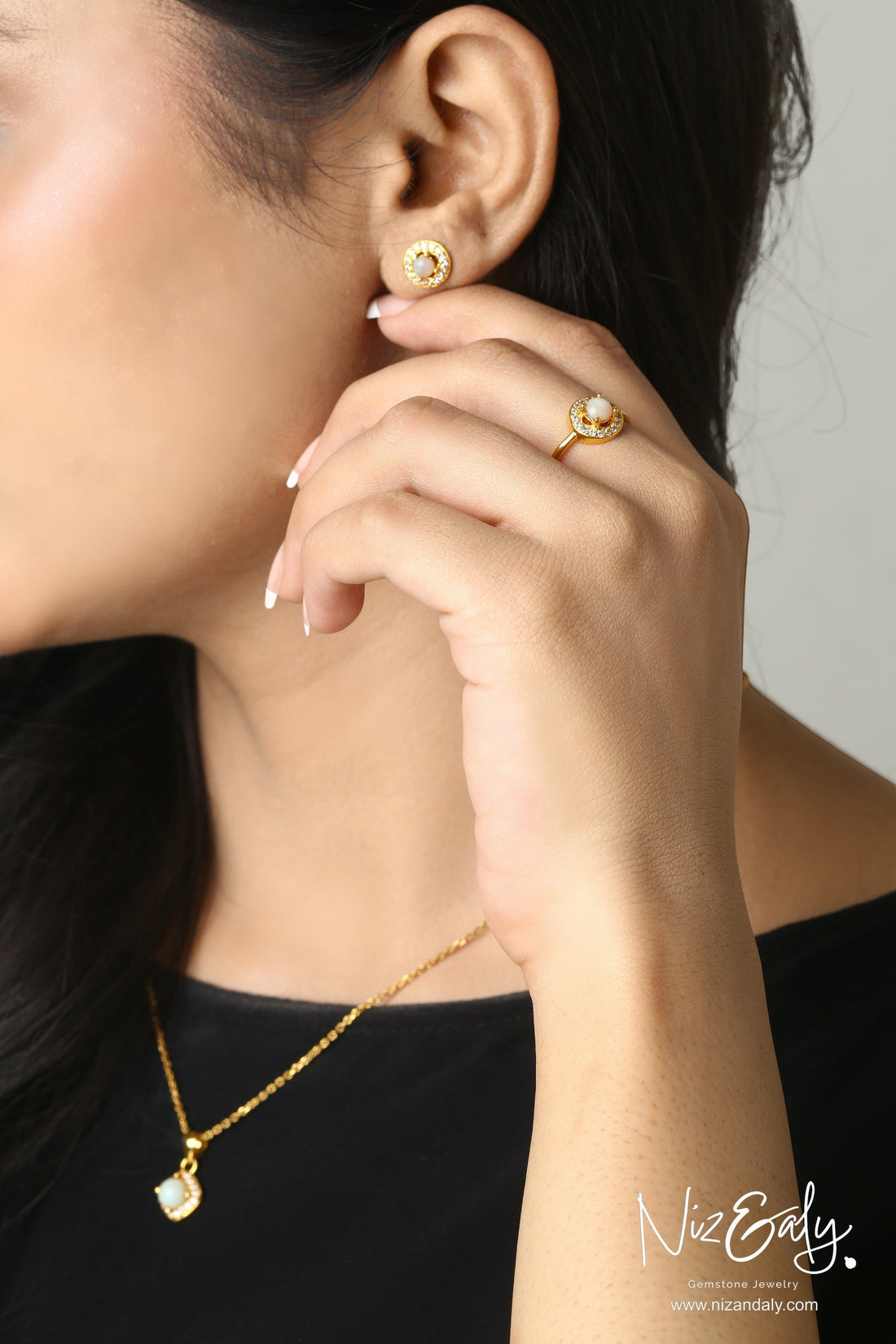 Niz & Aly dainty round white Australian opal necklace, stud earrings, and ring set with halo on a woman