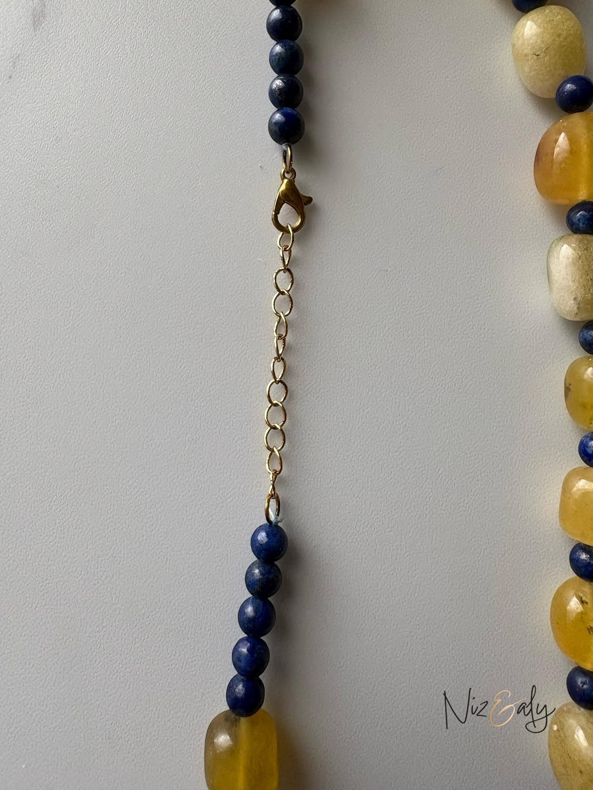 Niz & Aly necklace featuring yellow agate and blue lapis lazuli beads with a gold-tone metal lobster clasp extender