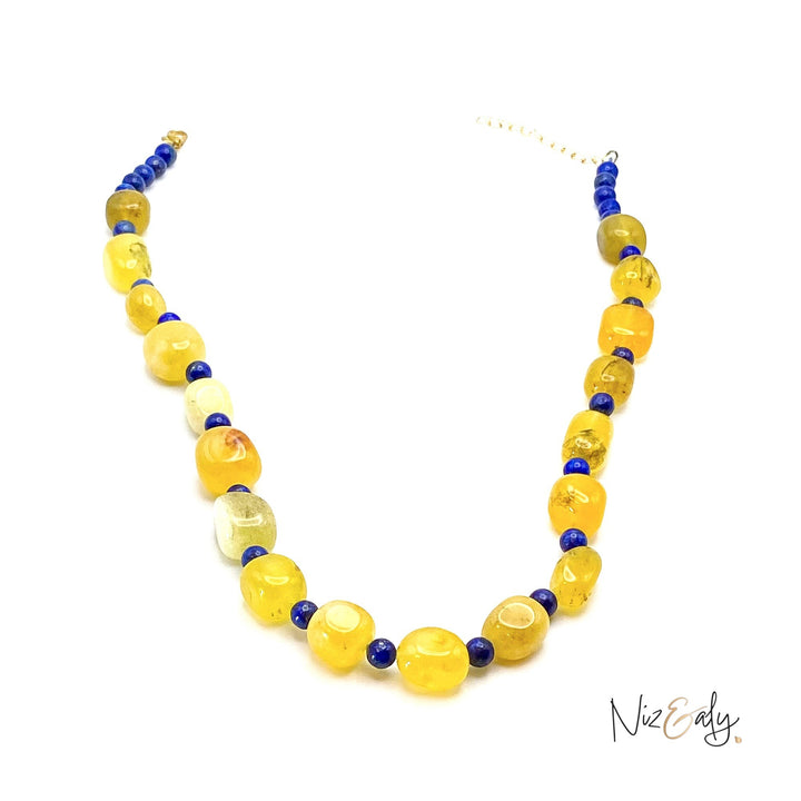 Niz & Aly necklace featuring vibrant yellow agate nuggets and small deep blue lapis lazuli beads on a white background.