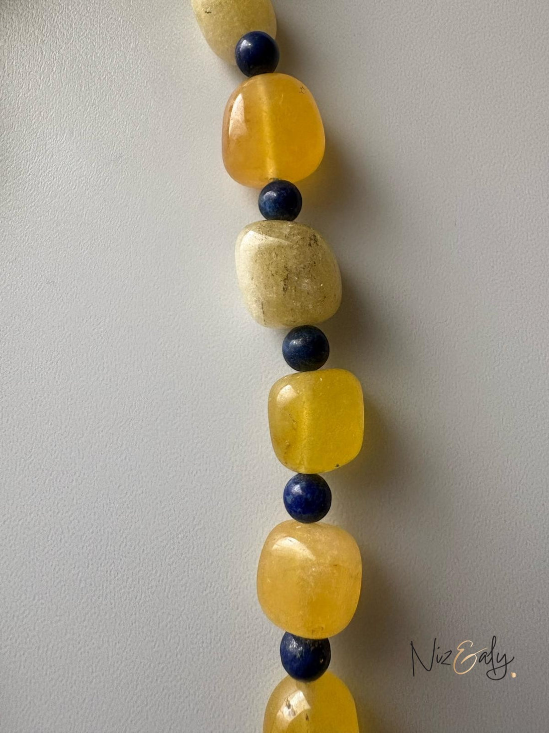 Niz & Aly necklace featuring alternating tumbled yellow agate and small round blue lapis lazuli gemstone beads.