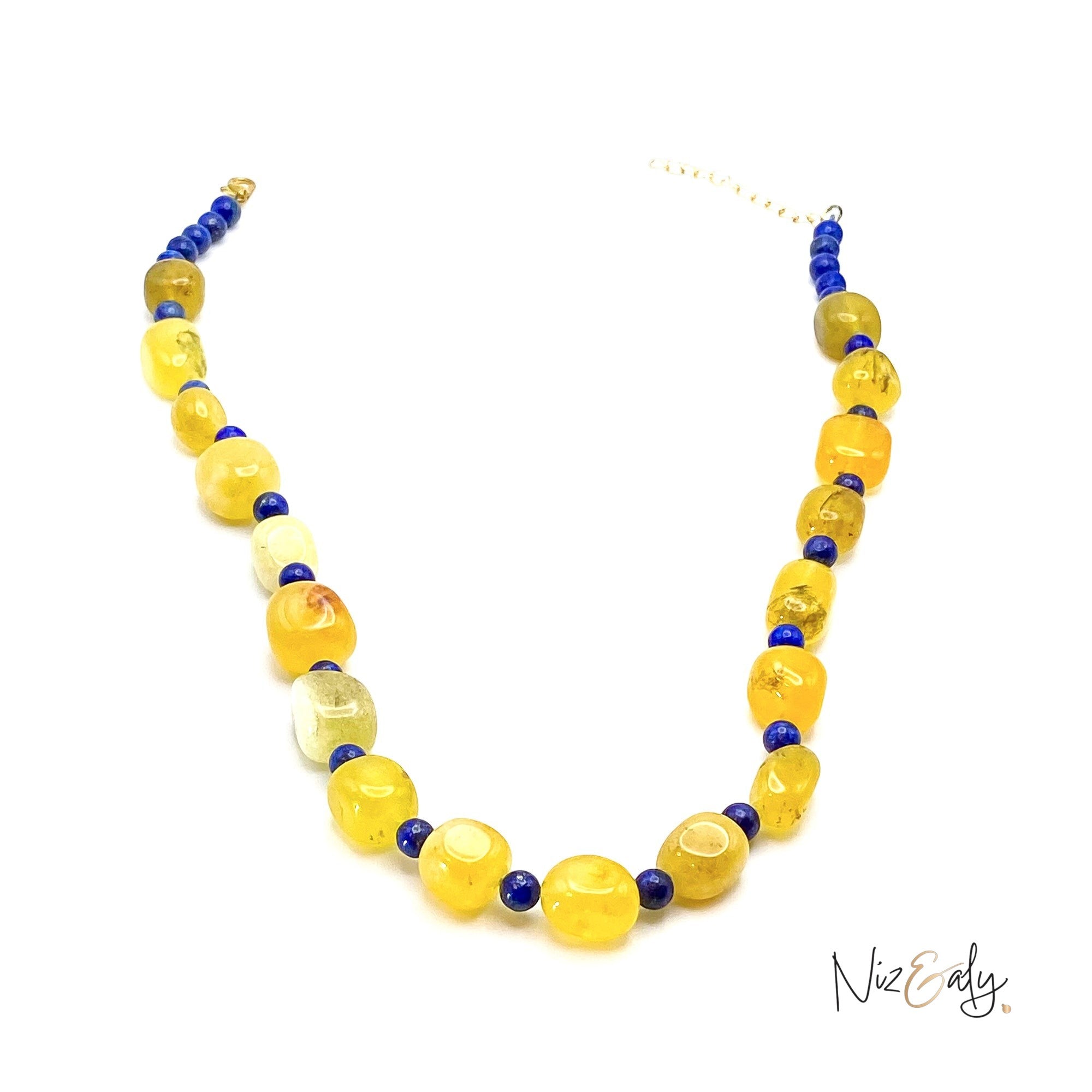 Niz & Aly necklace featuring polished yellow agate nuggets and small blue lapis lazuli beads on a white background.