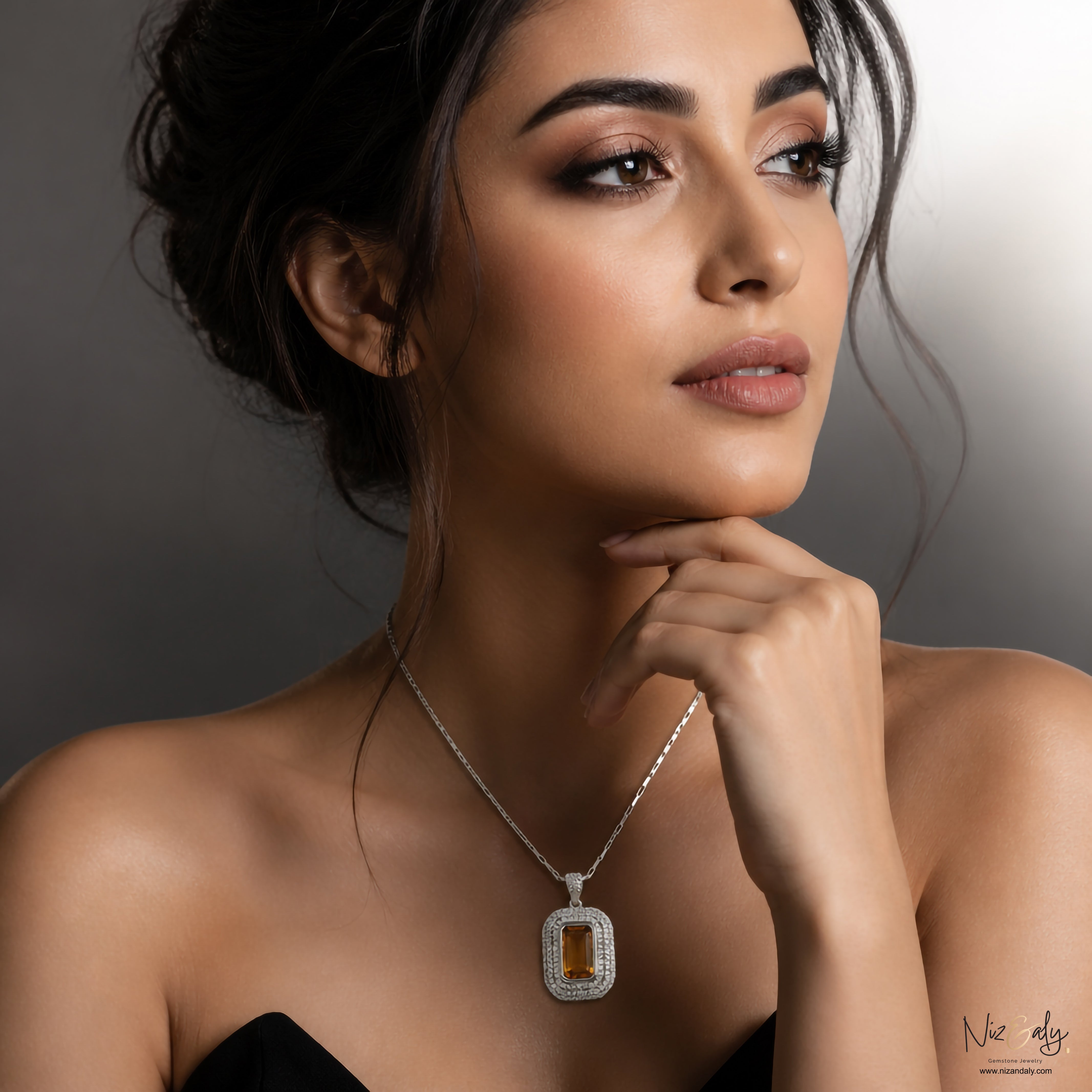 A woman wearing a Niz & Aly yellow amethyst pendant necklace with a diamond halo setting on a silver chain.