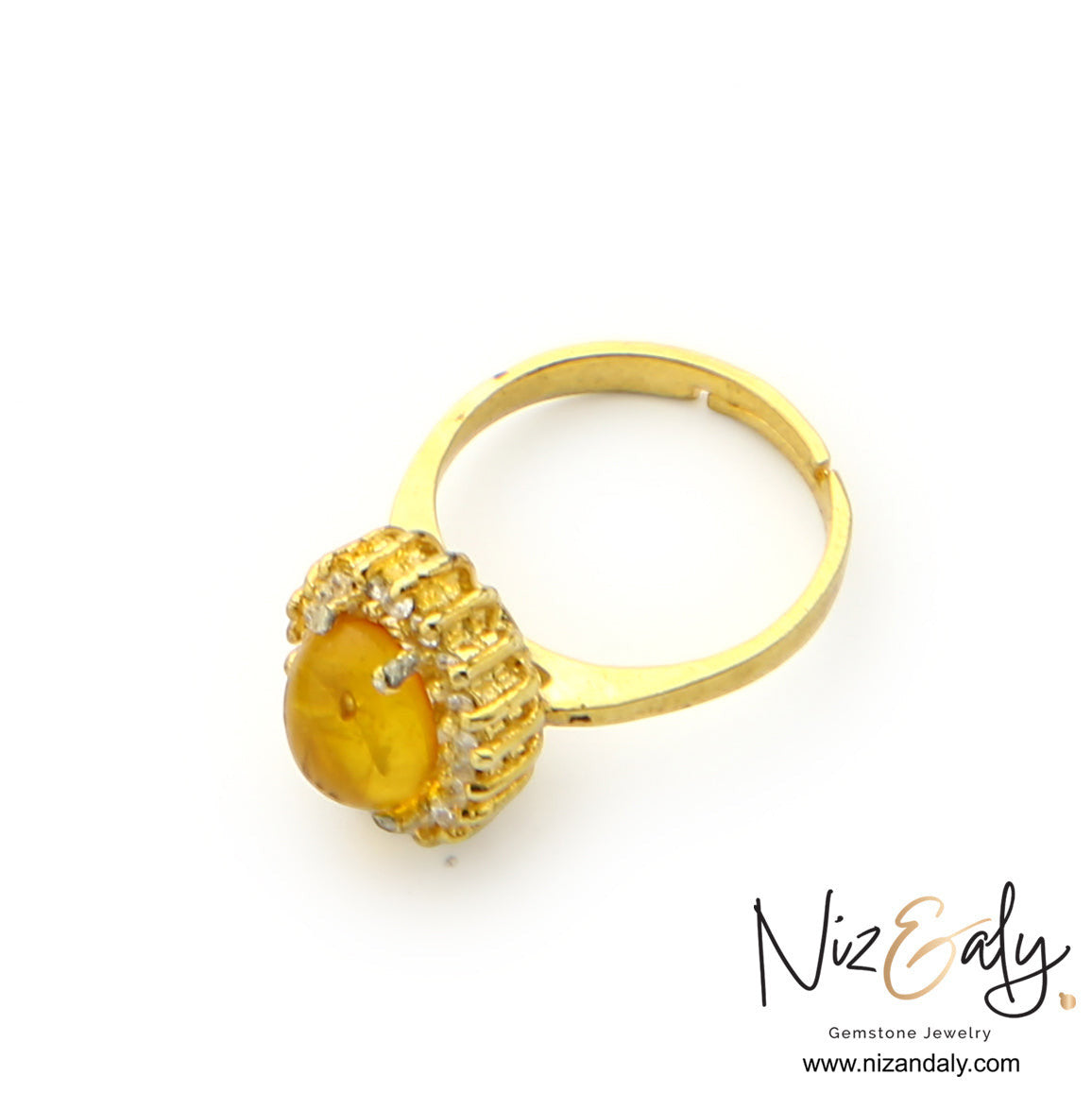 Niz & Aly yellow Baltic amber ring with gold-plated setting and sparkling clear stone accents on a white background