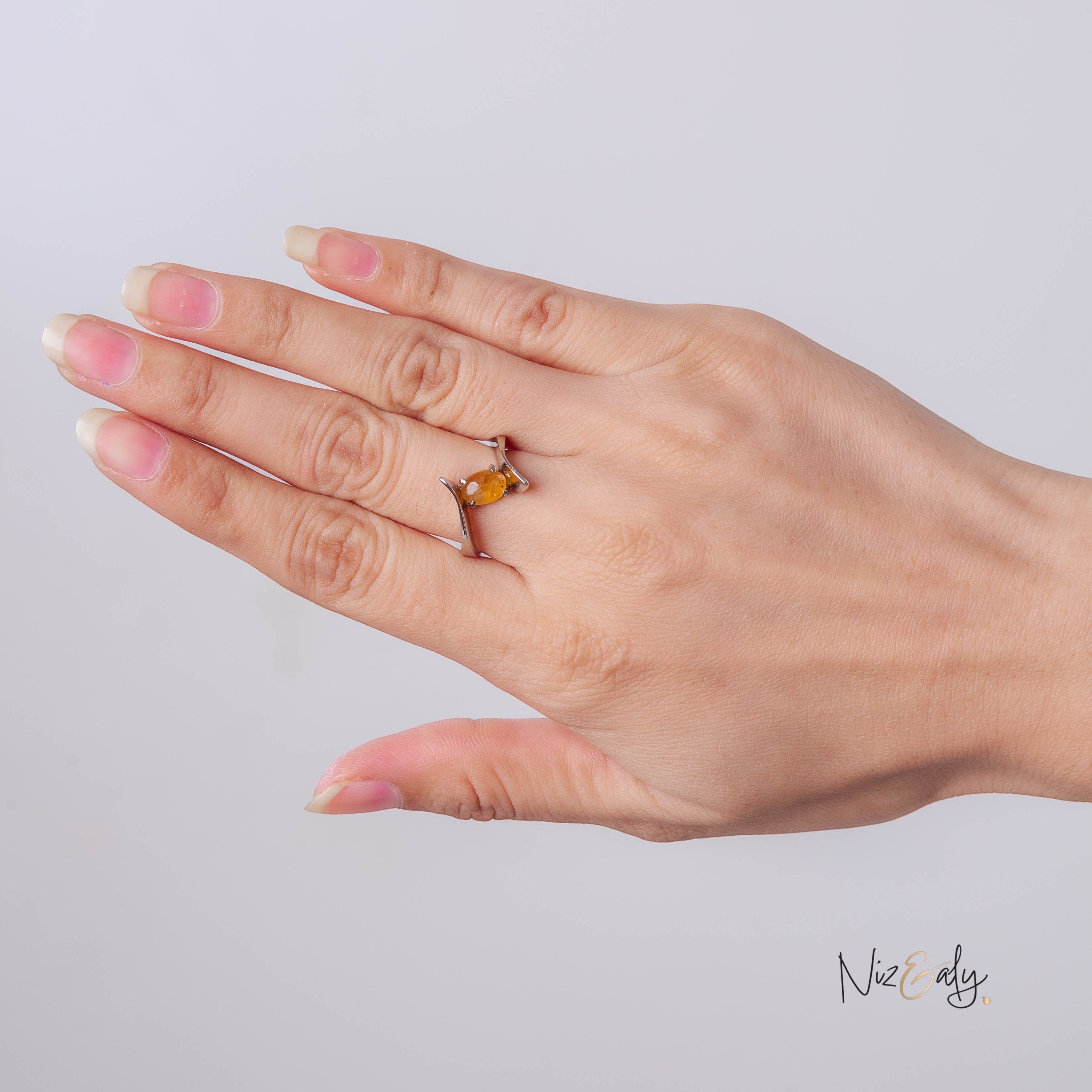 Niz & Aly yellow citrine gemstone ring with a modern silver-tone open-bypass band worn on a hand.