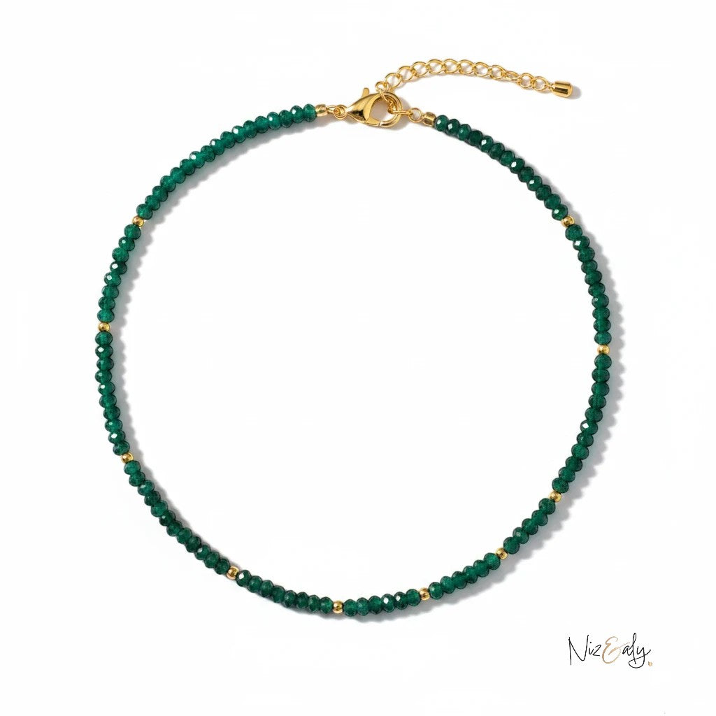 Niz & Aly necklace featuring faceted green Zambian emerald rondelle beads with small gold accents on a white background