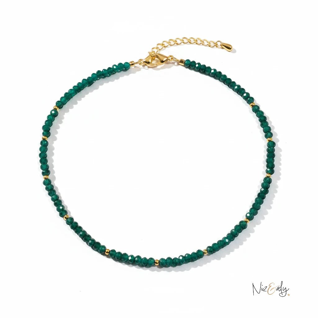 Niz & Aly natural Zambian emerald beaded necklace with faceted rondelle stones and gold accents on a white background.