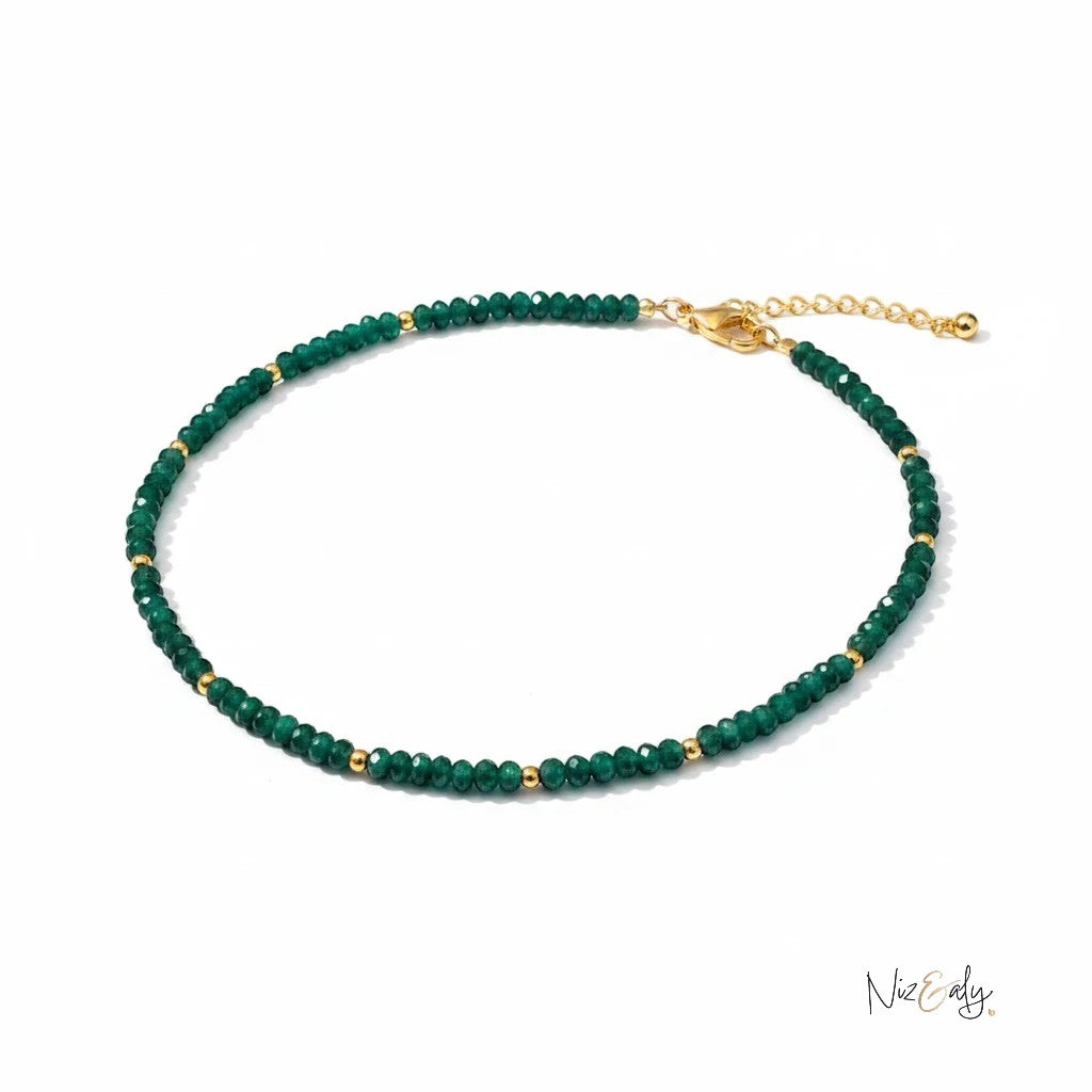 Niz & Aly natural Zambian emerald beaded necklace with faceted green rondelle stones and gold accents on a white background