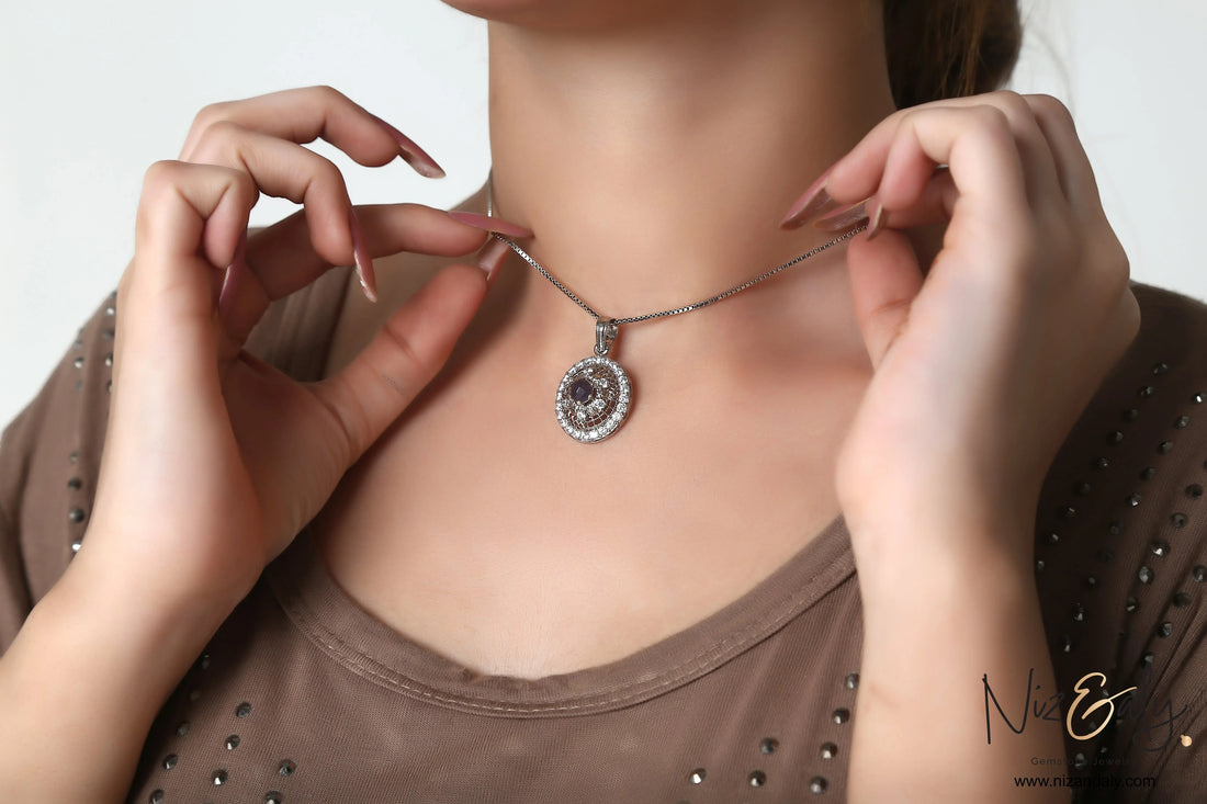 Niz & Aly round natural amethyst pendant with white cubic zirconia halo on a silver chain worn by a woman