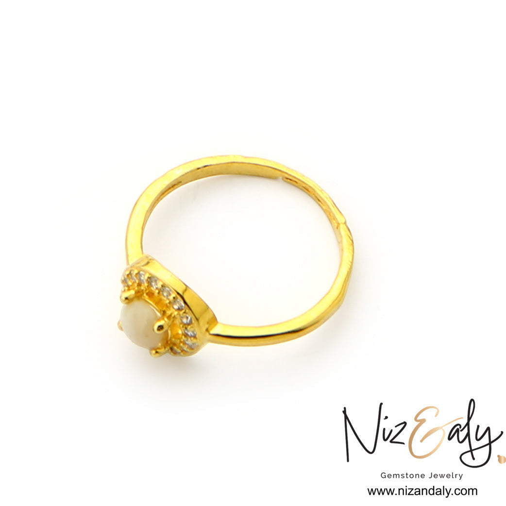Niz & Aly dainty gold ring featuring a round white Australian opal surrounded by a sparkling halo of clear stones.