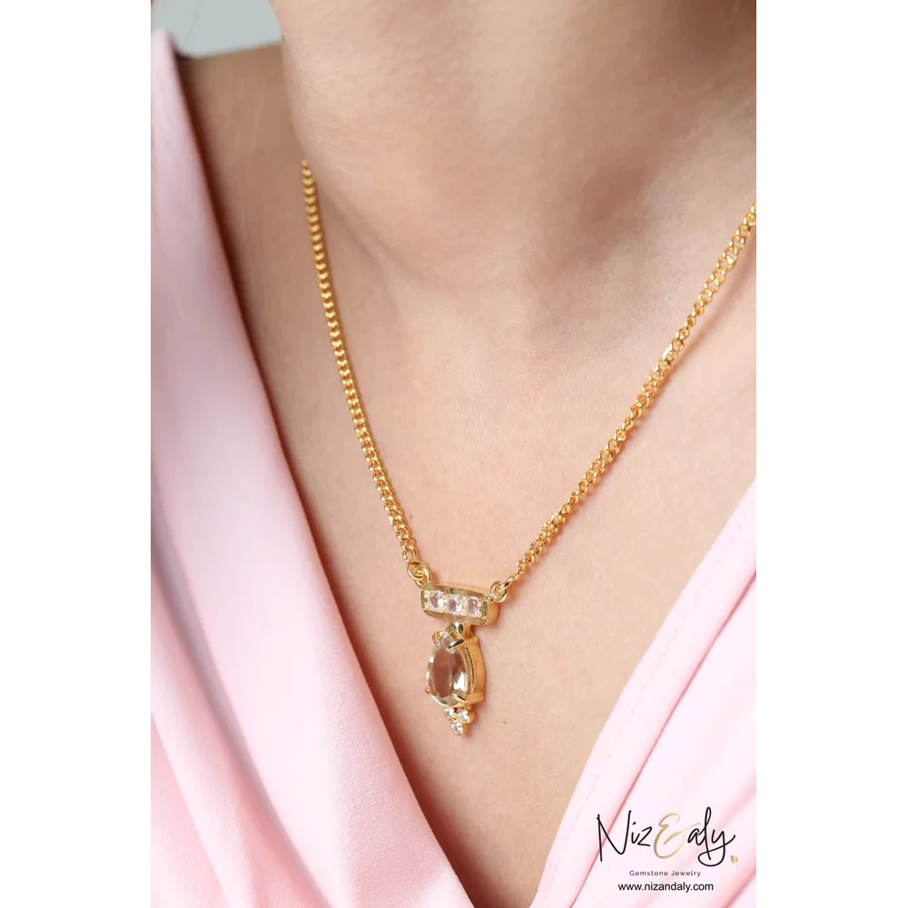 Niz & Aly gold-plated sterling silver necklace featuring a faceted teardrop clear quartz pendant on a delicate chain.