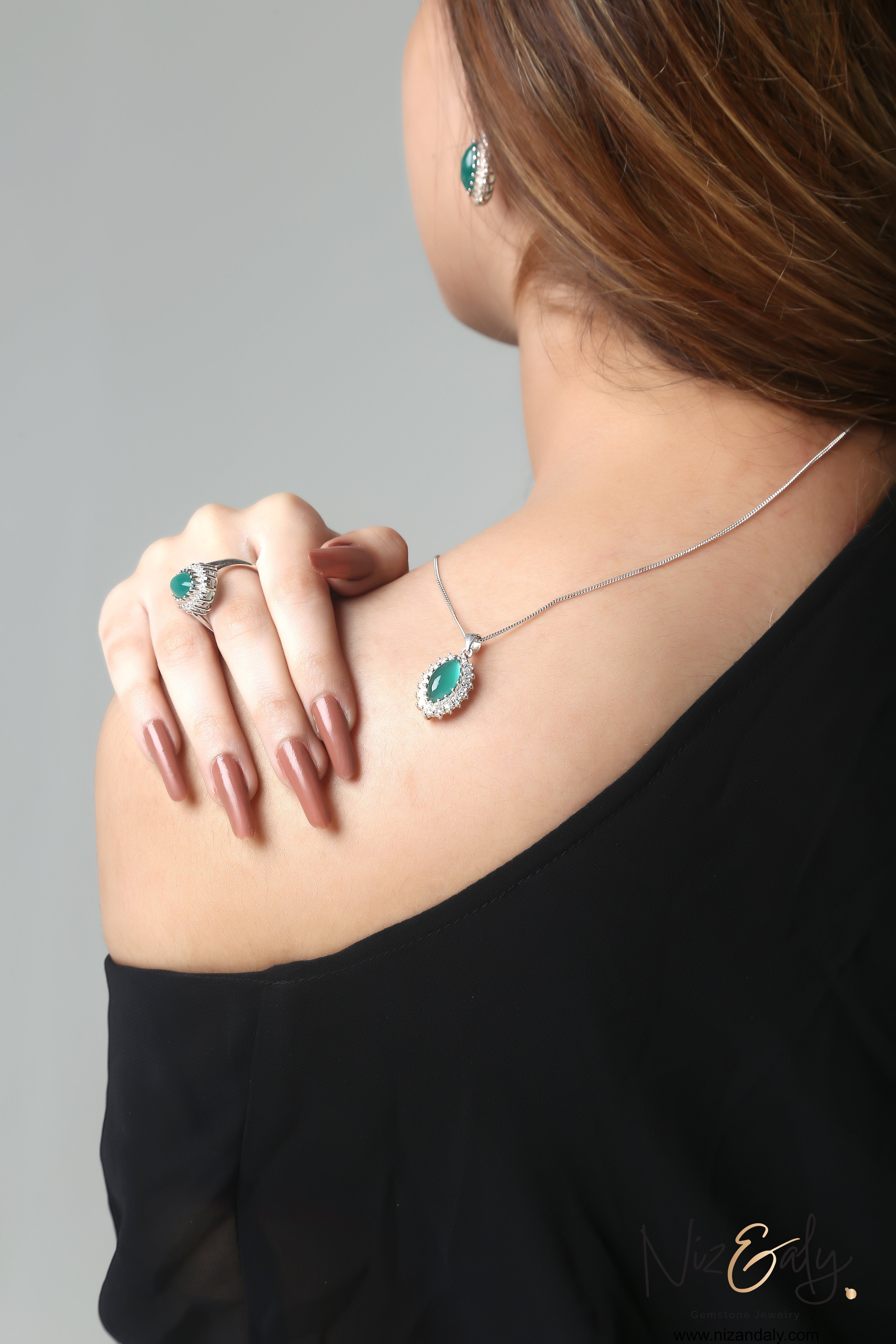 Niz & Aly marquise cut green chrysoprase pendant and earring set with silver setting worn on a model