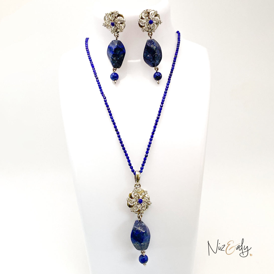 Niz & Aly lapis locket necklace and matching earrings set with deep blue faceted lapis beads on a white display bust