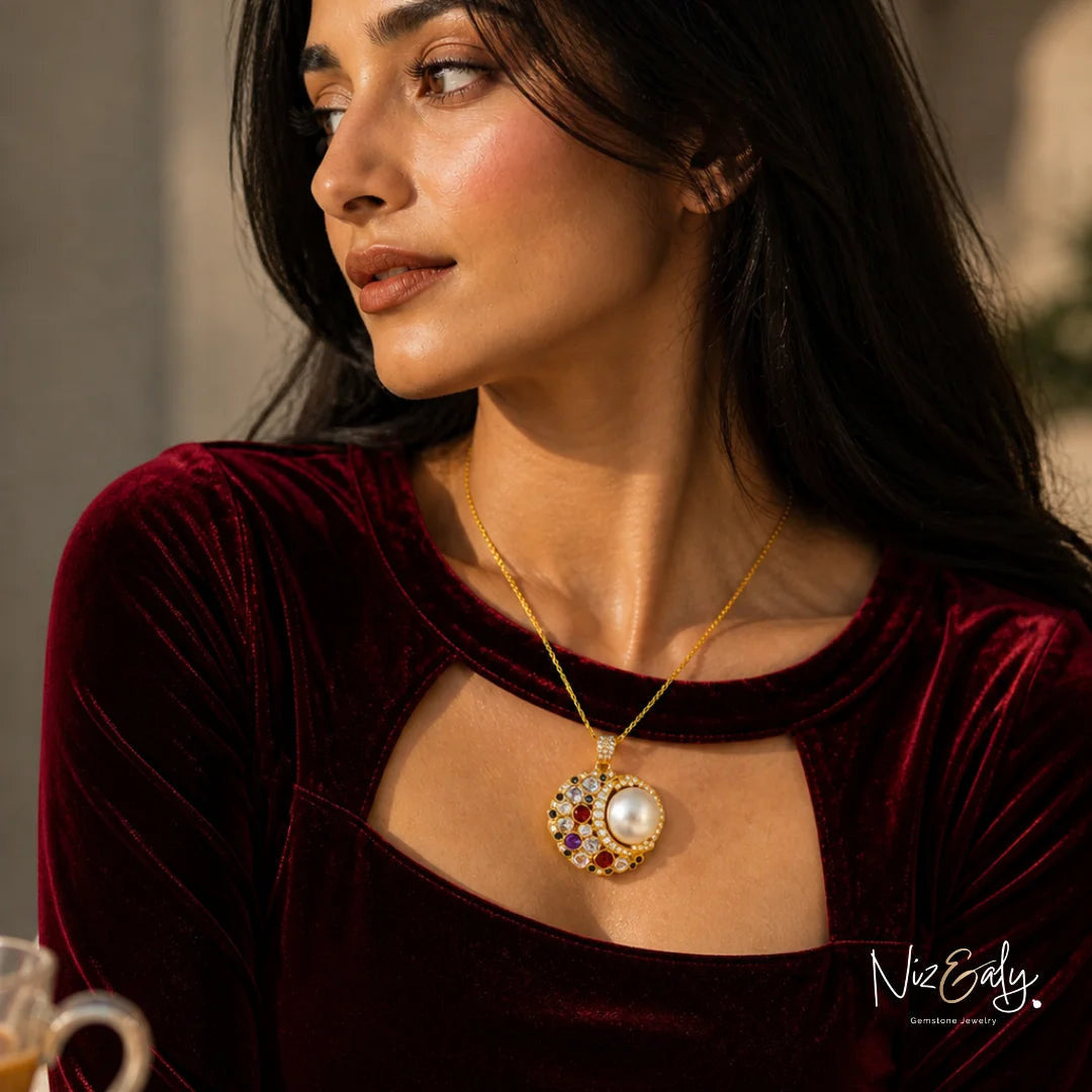 Niz & Aly handcrafted mabe pearl pendant necklace with amethyst, garnet, and sapphire gemstones on a gold rope chain.