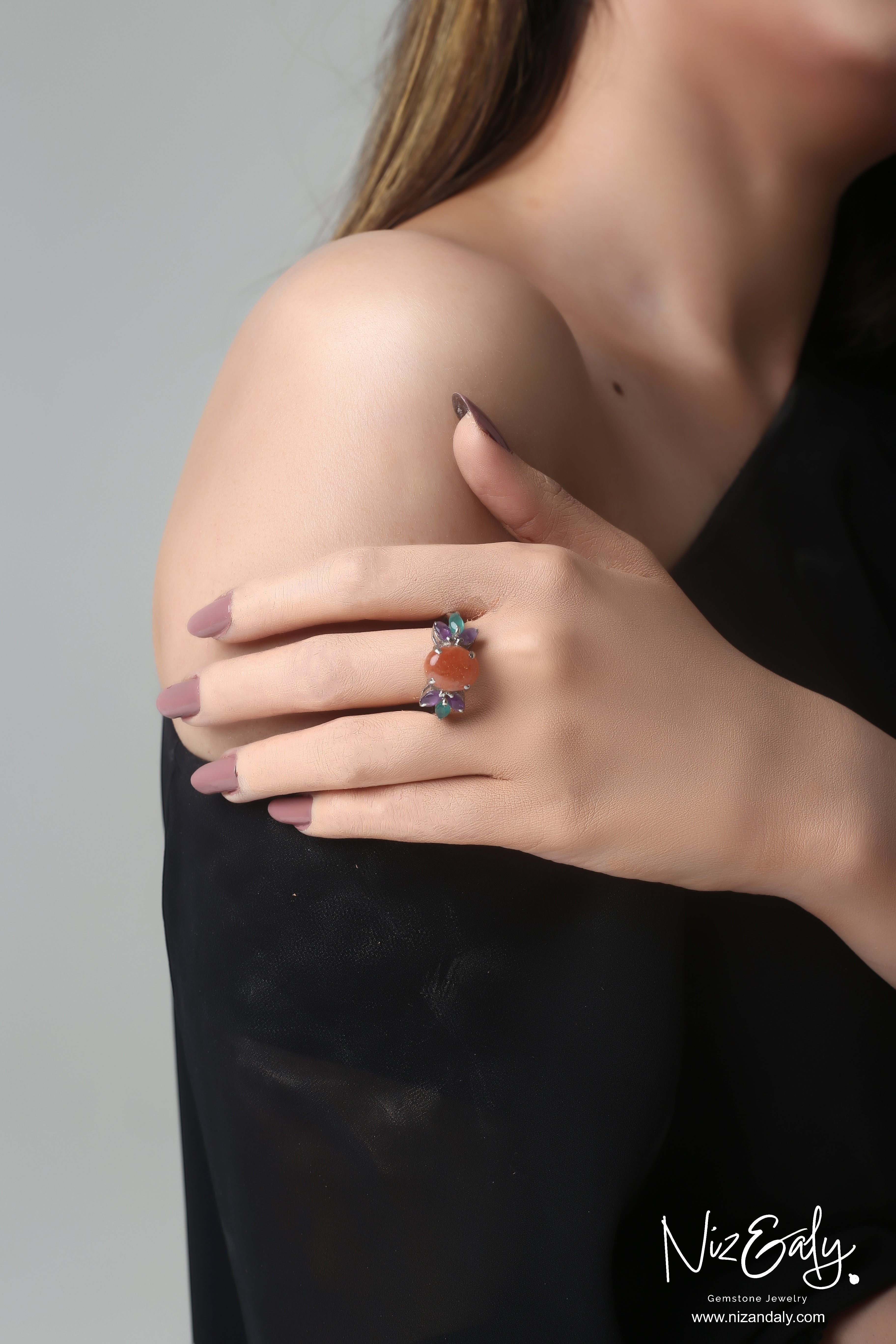 Niz & Aly 925 sterling silver ring featuring sunstone, amethyst, and chrysoprase gemstones on a woman's hand.