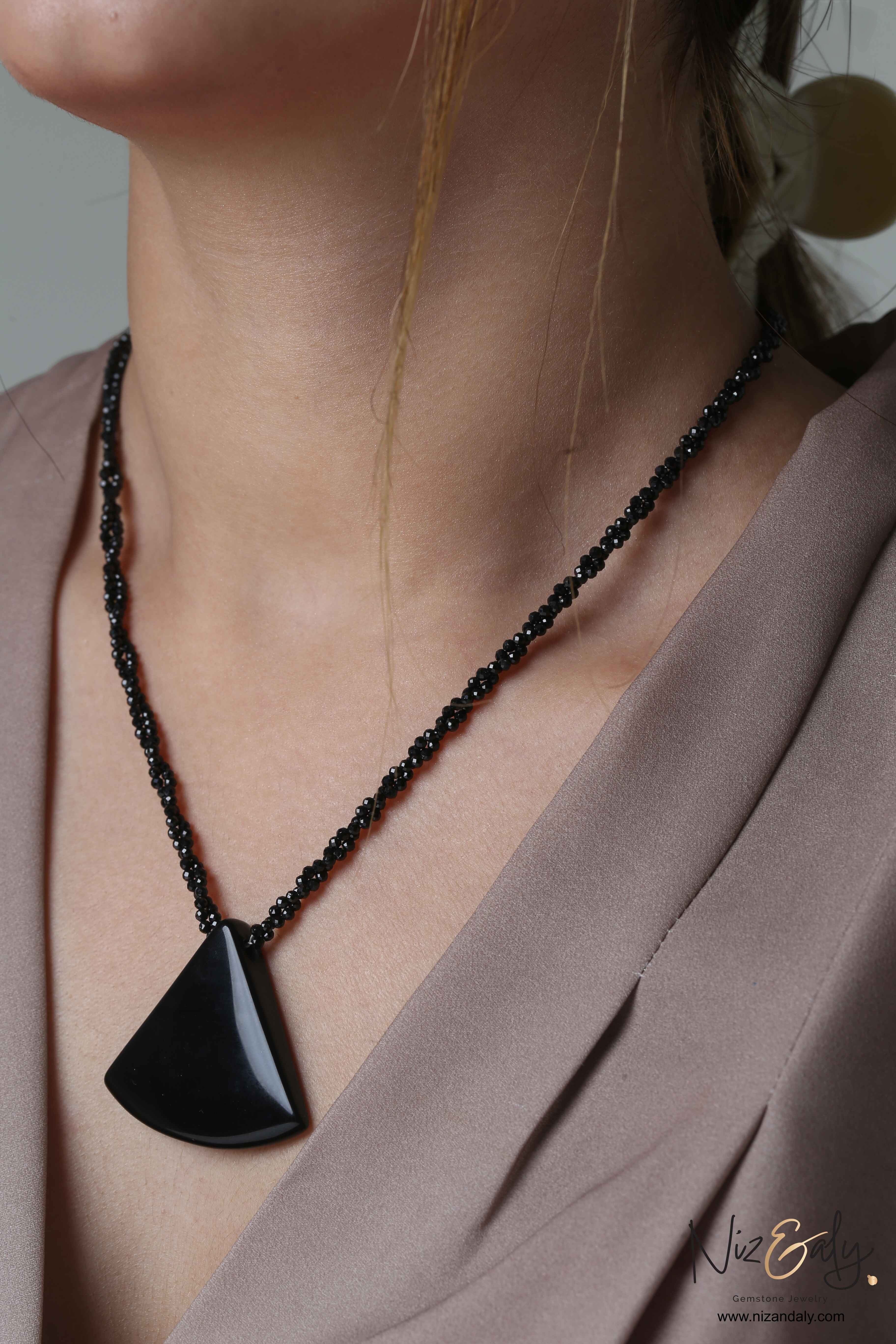 Niz & Aly Agate Eclipse necklace featuring a triangular black agate pendant on a twisted black onyx beaded chain.