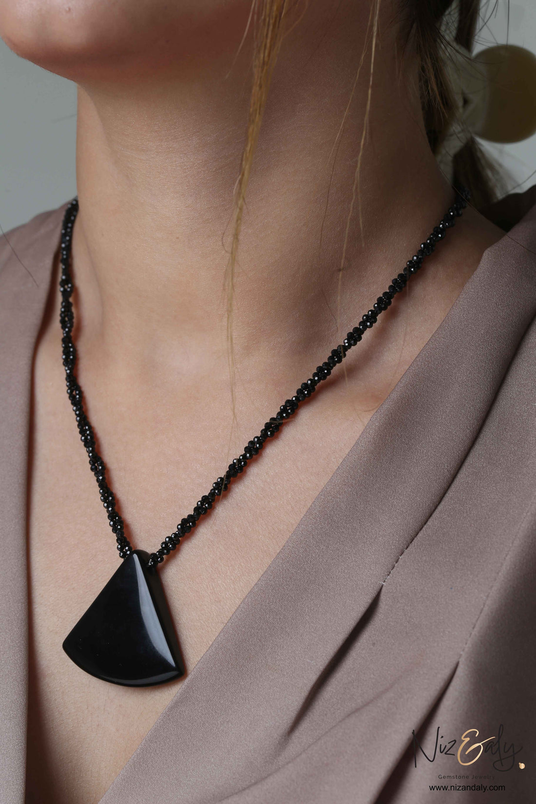 Niz & Aly Agate Eclipse necklace featuring a triangular black agate pendant on a twisted black onyx beaded chain.