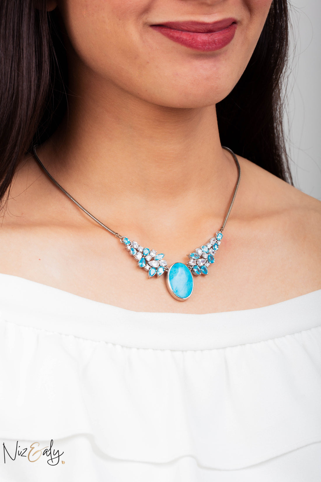 Niz & Aly Whisper of Nishapur statement necklace featuring a large oval turquoise stone with crystal accents.